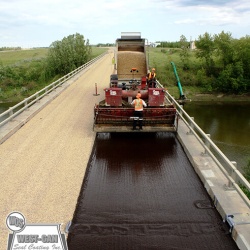Chip Sealing bridge decks increases the skid resistance and adds years of life to the underlying structure