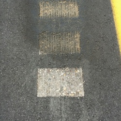 Sand Sealing rumble strips on paving project, notice the difference between the treated and untreated asphalt milled surface. 